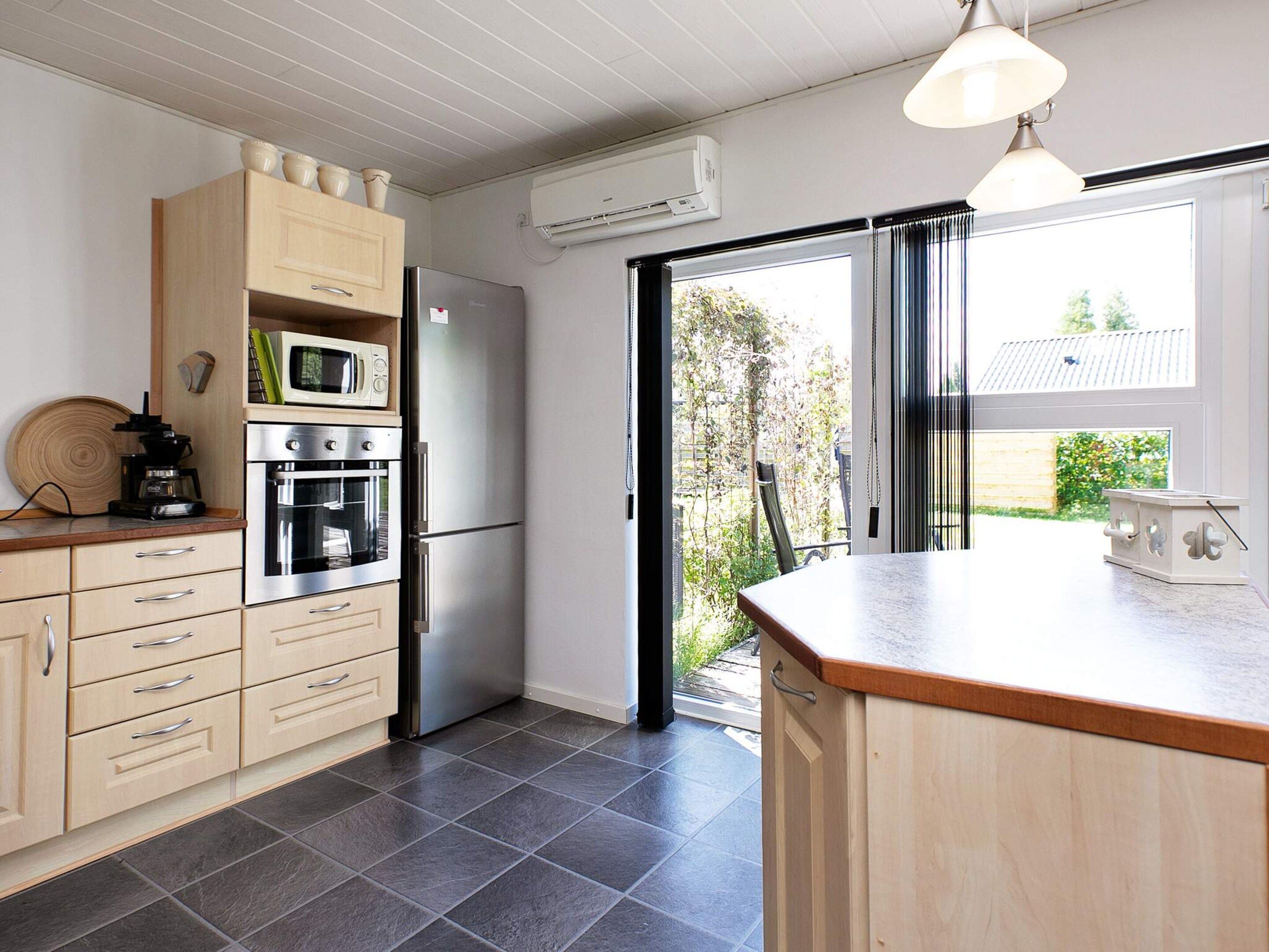 A modern kitchen with a built-in oven, microwave, and refrigerator.