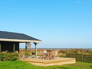 A covered outdoor area with a table and chairs, a barbecue grill, and a satellite dish. - 6 Person Holiday Home in Hadsund (Hadsund)