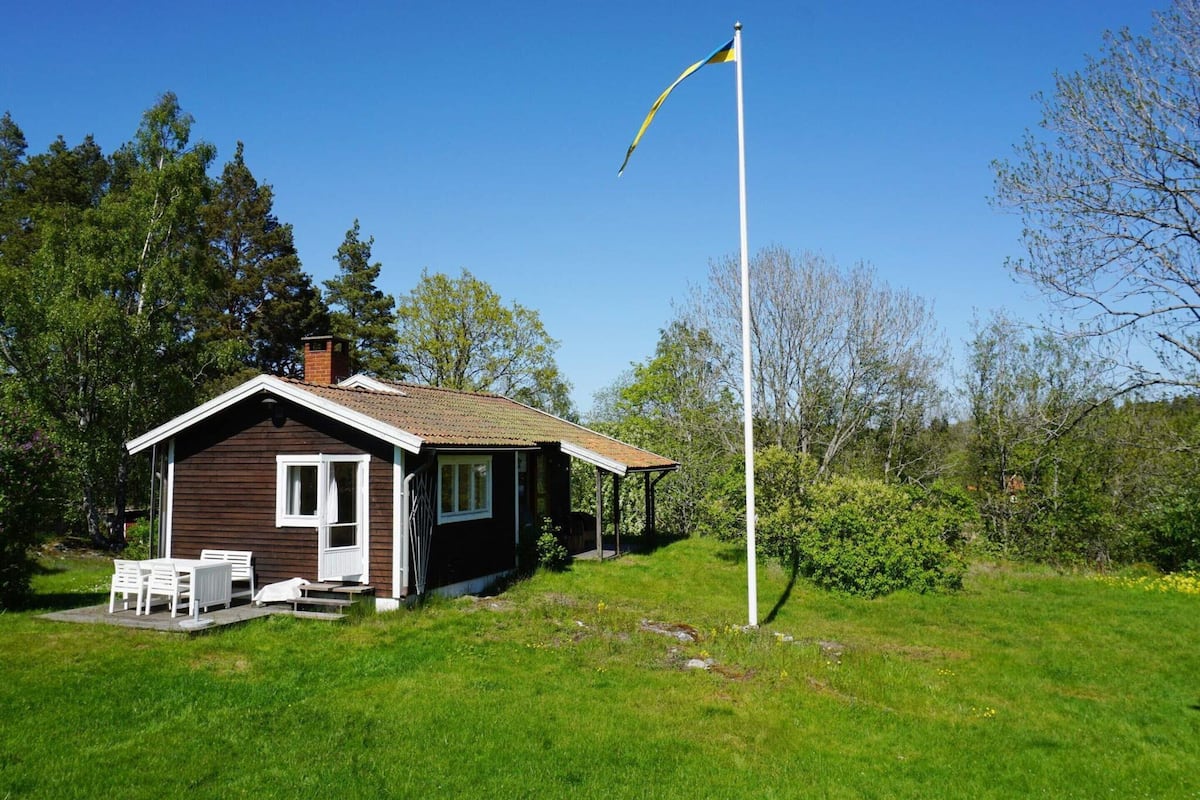 A small house with a porch and a flagpole.