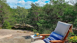 A wooden deck with a lounge chair and a small table with a book and a bowl. - 9 Person Holiday Home in Vesteroy (Hvaler)