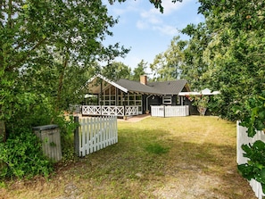 A house with a fenced yard, a covered porch, and a number '48' sign.
