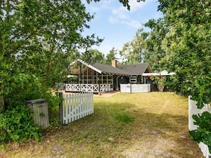A house with a fenced yard, a covered porch, and a number 48 sign. - Holiday Home in Hadsund (Hadsund)