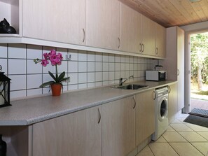 A kitchen with a sink, a microwave, and a washing machine.