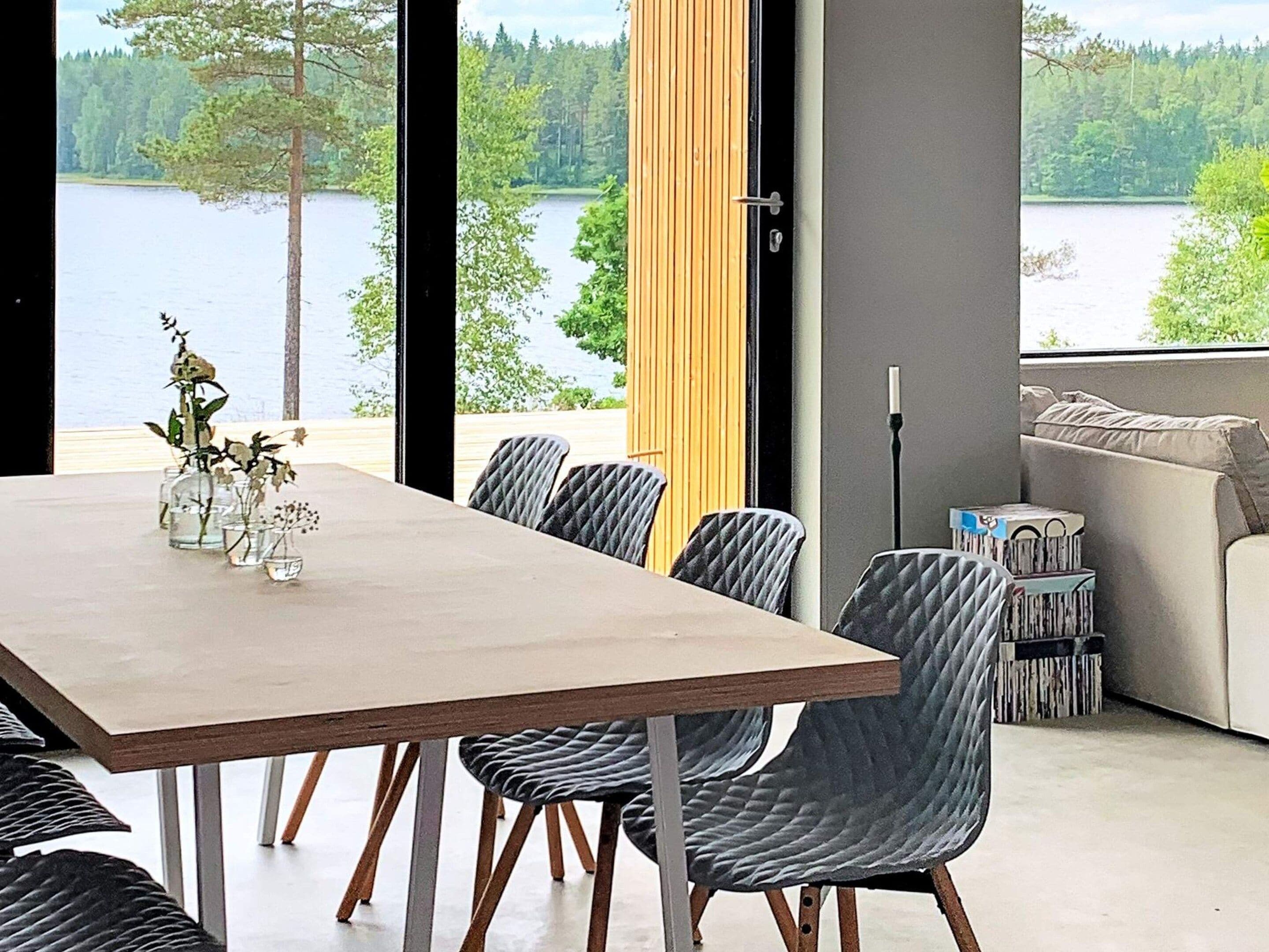 Un comedor con vista a un lago, un sofá y una lámpara.