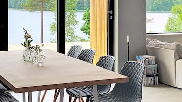 Un comedor con vista a un lago, un sofá y una lámpara.