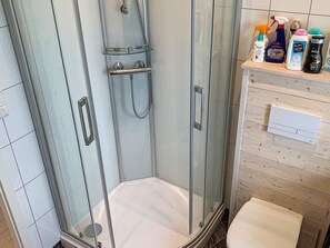A glass-enclosed shower stall with a white floor, a glass door, and a chrome showerhead. - 5 Person Holiday Home in Torrvikbygd (Kvam)