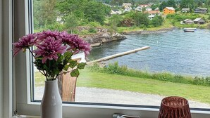 A window view of a river with houses and mountains in the background. - 5 Person Holiday Home in Torrvikbygd (Kvam)