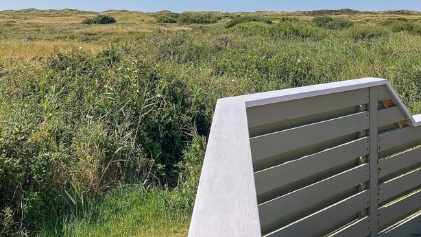A white bench in a grassy field with a clear sky. - Holiday Home in Rømø (Rømø)