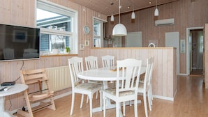 A modern kitchen with a central island, white cabinetry, and a large window.