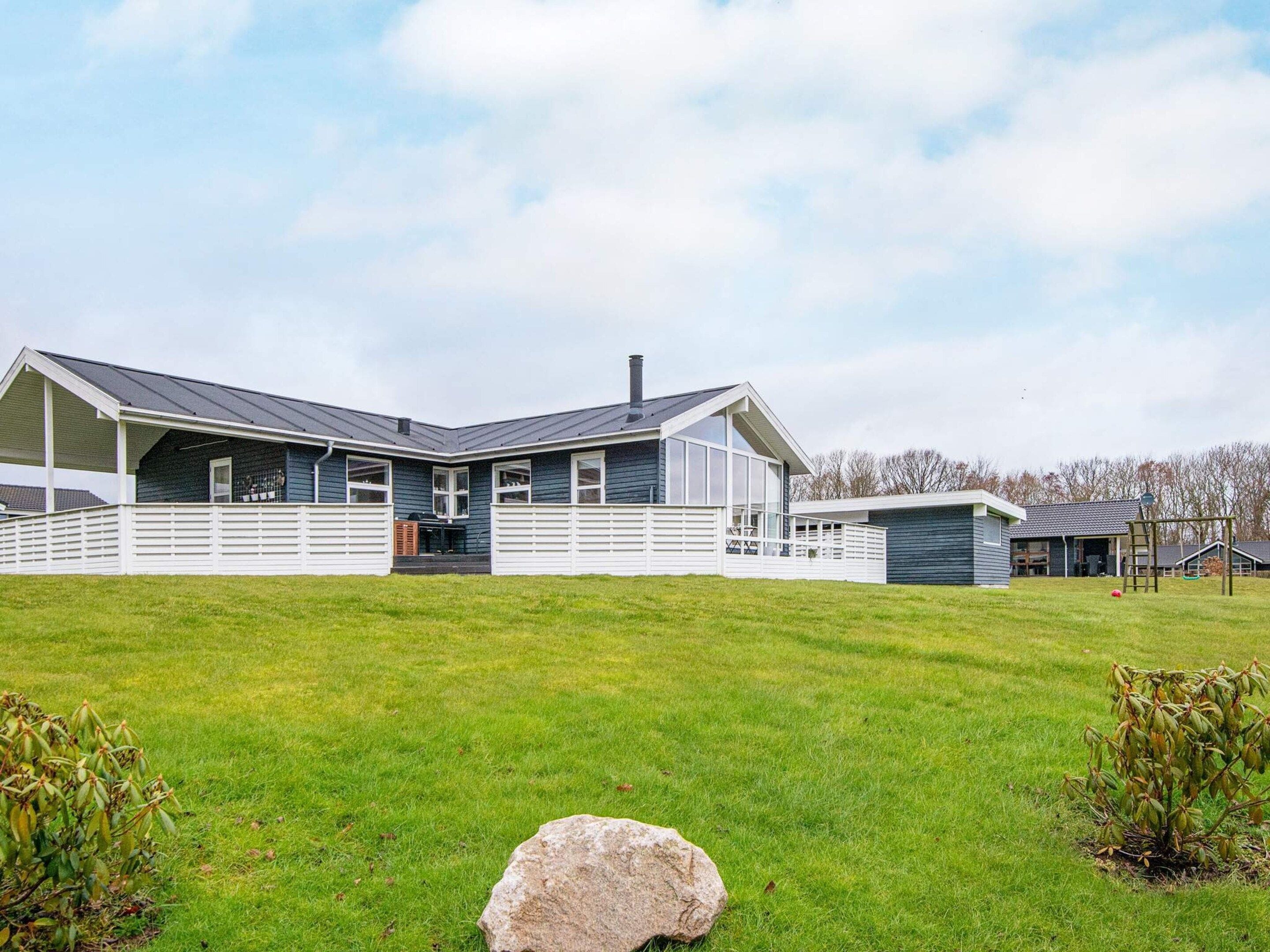 Ein zweistöckiges Haus mit einer Veranda und einer separaten Garage.
