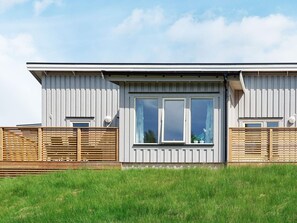A modern building with a flat roof, large windows, and a wooden fence. - 4 Star Holiday Home in Stromstad (Stromstad)
