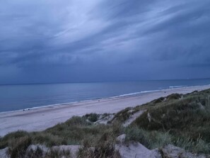 A beach with dunes and a cloudy sky. - Holiday Home in Henne (Henne)