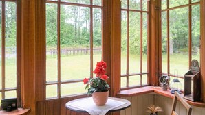 A room with a large window overlooking a grassy area, a small table with a potted plant, and a chair. - 4 Person Holiday Home in Jamjo (Jämjö)