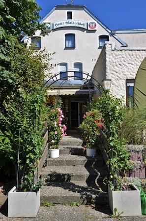 A building with a sign reading 'Hotel Waldschlöss' and a logo for 'ERDINGER'. - Hotel Waldschloss (Bad Camberg)