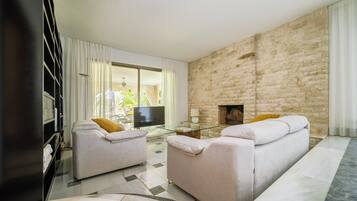 Una televisión, una chimenea, una mesa de tenis de mesa, libros