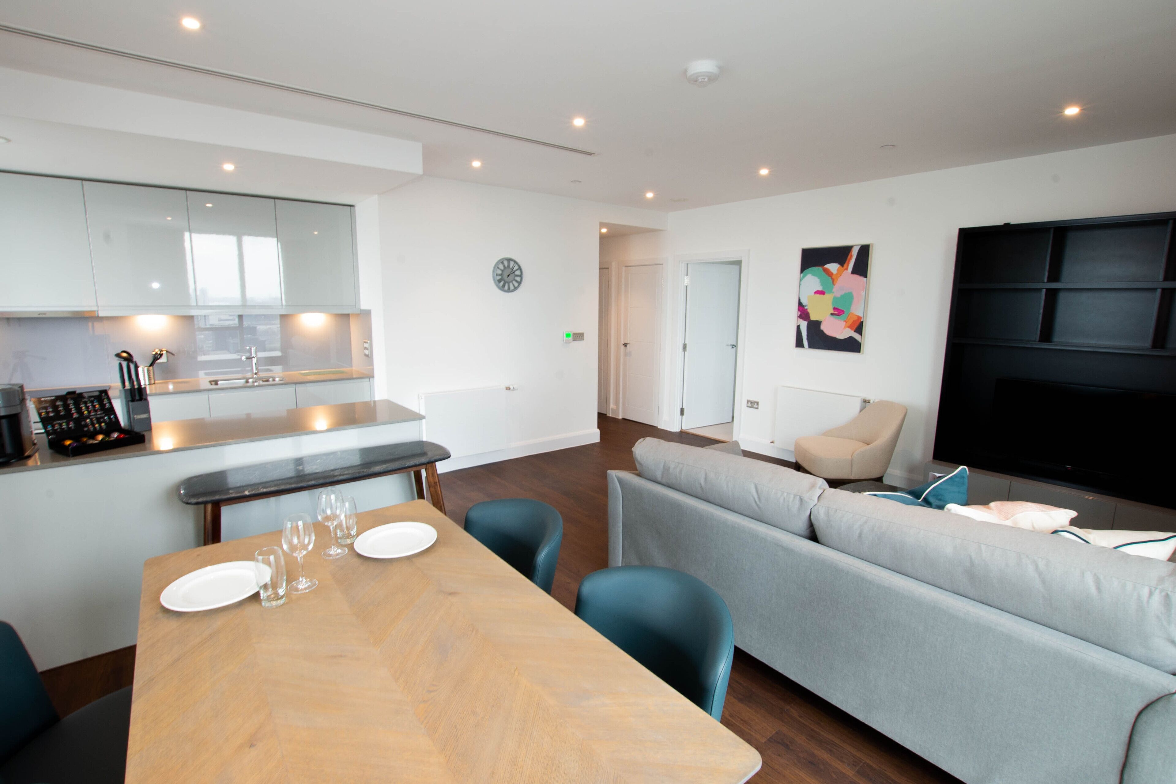 Een moderne hotelkamer met een eethoek, een bank en een flatscreen-televisie.