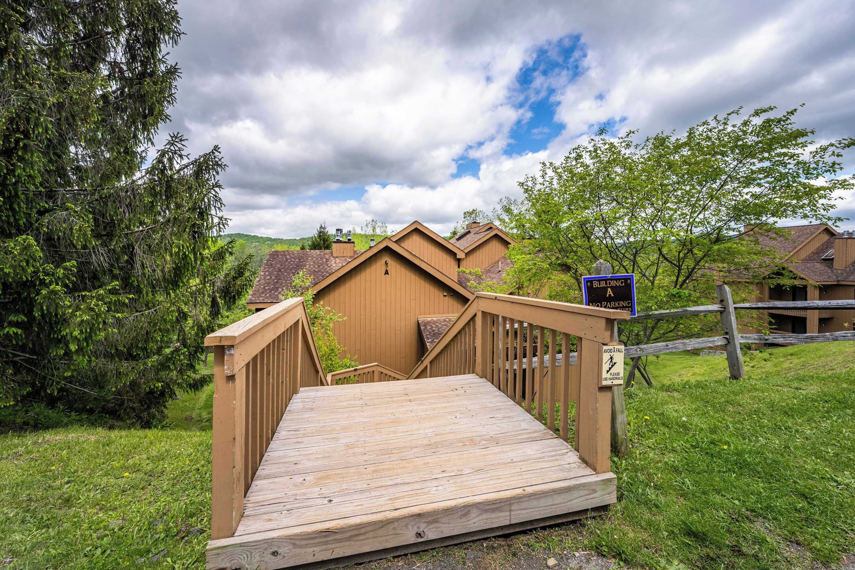 A wooden bridge leading to a building with a sign indicating no parking.