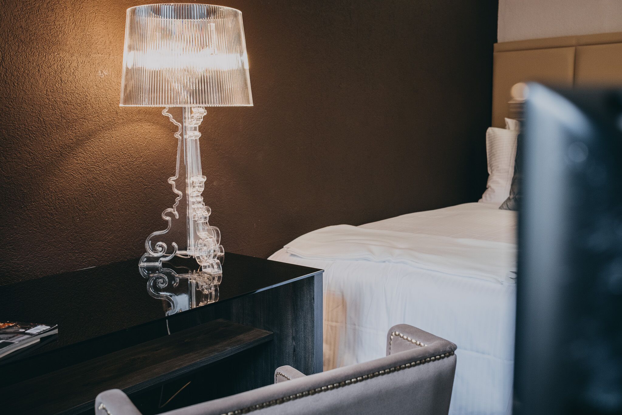 Une chambre d’hôtel avec un lit, un bureau doté d’une lampe et une chaise.
