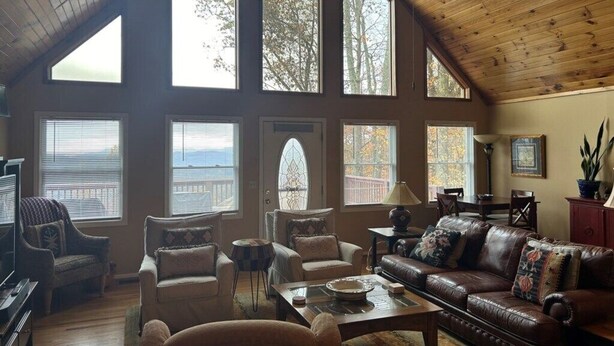 A spacious loft-style living room with high ceilings, large windows, and a view of the outdoors. - Ascendere - Amazing mountain views, 3 bedroom, 2 bath, central heat/AC, private. (Maggie Valley)
