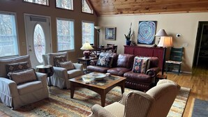 A spacious living room with a large window, a fireplace, and a dining area. - Ascendere - Amazing mountain views, 3 bedroom, 2 bath, central heat/AC, private. (Maggie Valley)