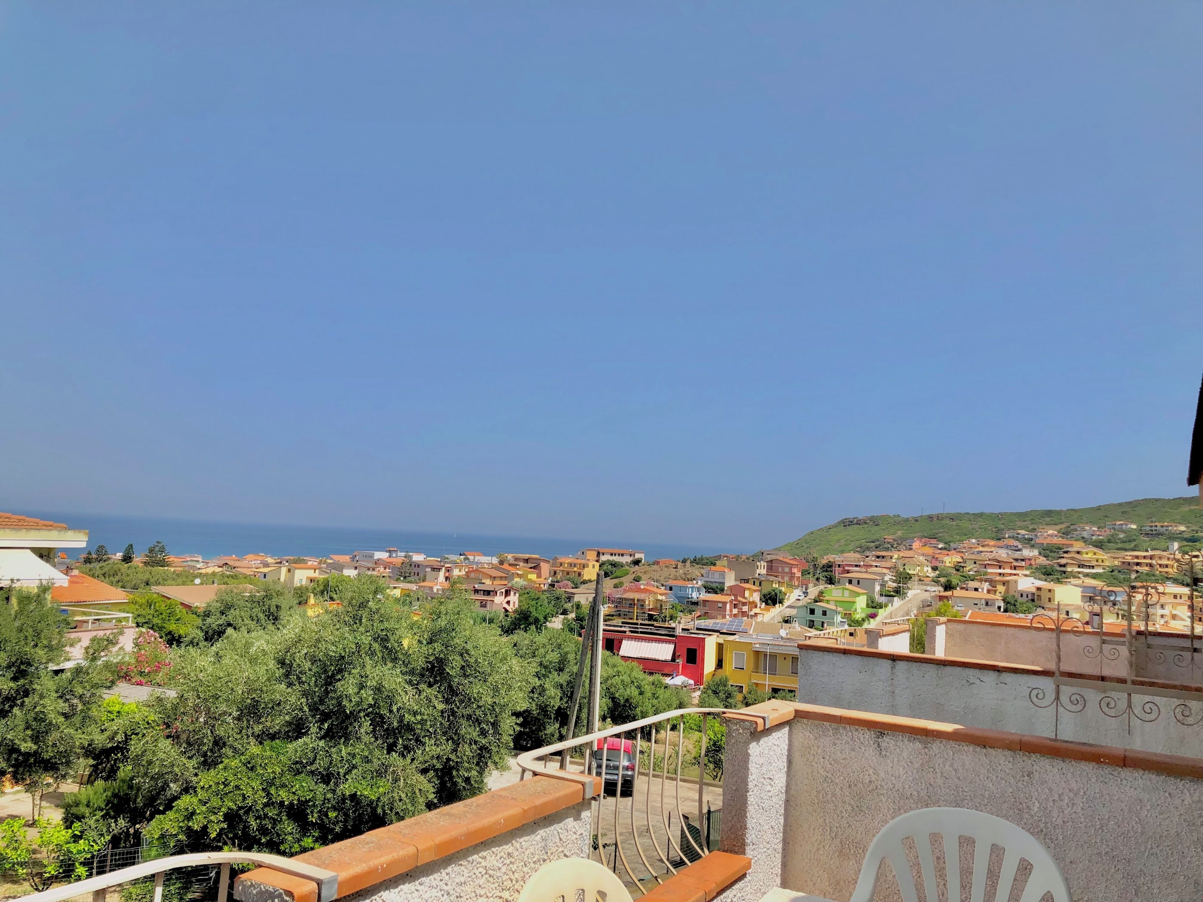 Ein Wohngebiet mit freiem Blick auf das Meer und einer hügeligen Landschaft im Hintergrund.