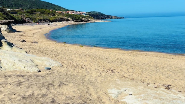 A sandy beach with scattered rocks and a clear blue sky. - Residence L'Ancora (Castelsardo)