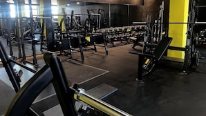 A gym with various weightlifting equipment, benches, and dumbbells. - Residence L'Ancora (Castelsardo)