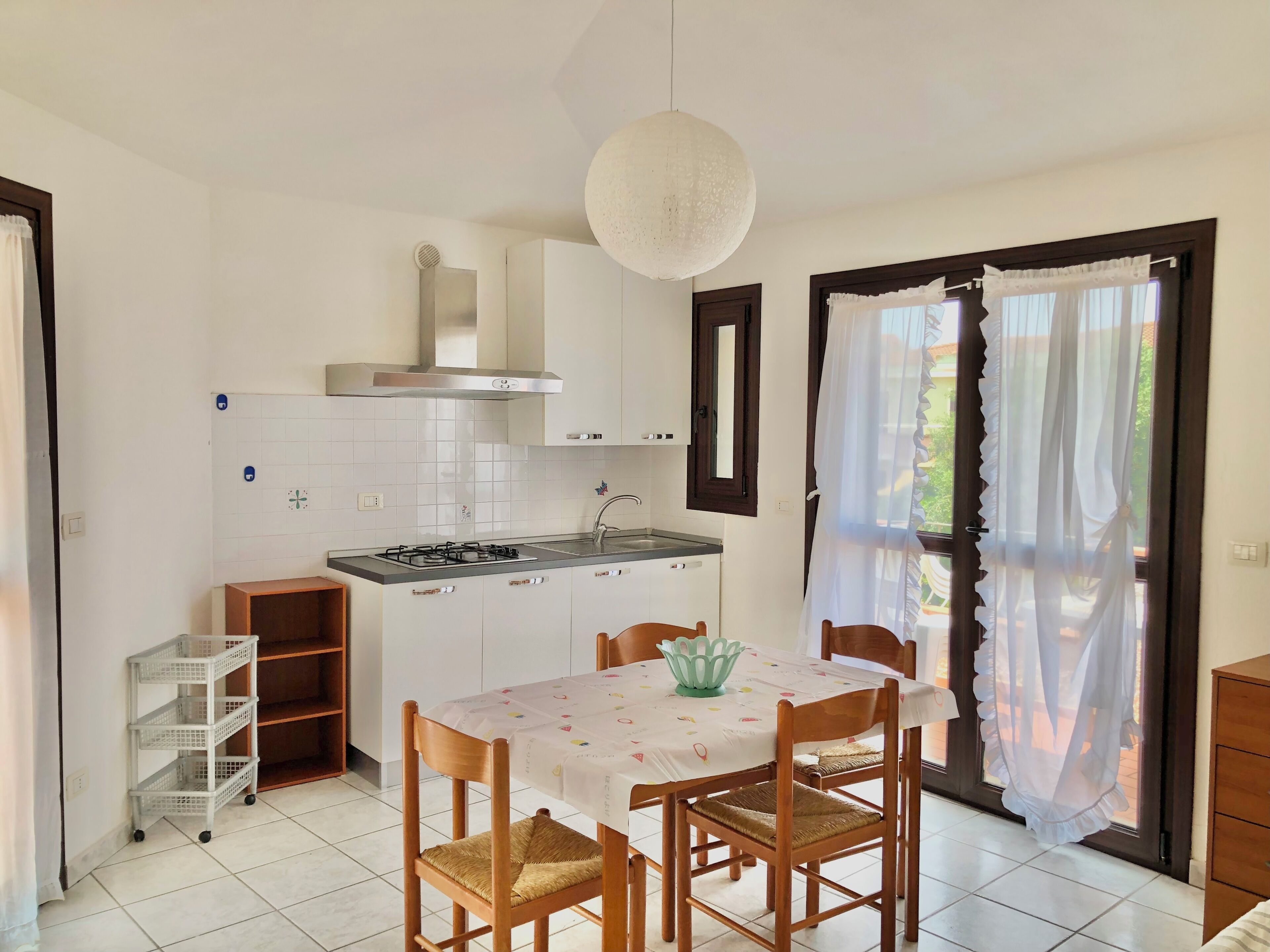 A kitchen with white cabinets, a gas stove, and a dining table with chairs.