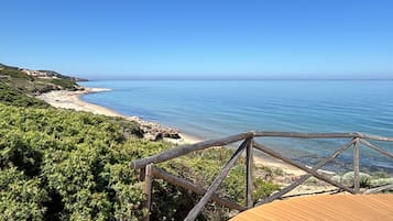 A beach with a wooden boardwalk and a clear blue sky.