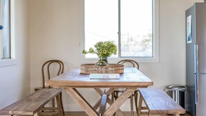 Un tavolo da pranzo in legno con panche, un vaso con fiori e un libro intitolato 'Faiastin'.