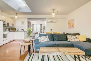 Una sala de estar moderna con un sofá gris, una mesa de centro de madera y un tapete a rayas.