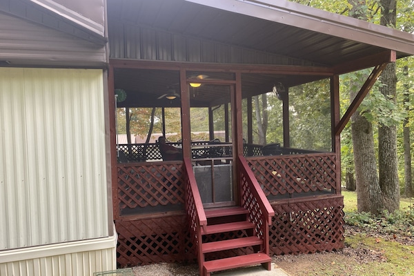 Large back deck with 2 ceiling fans and overlooking wooded yard