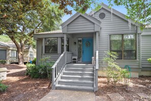 A single-story house with a front porch, a blue door, and a small front yard.
