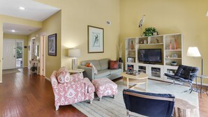 Un salon spacieux comprenant un ensemble de canapés, une table basse, un meuble pour la télévision et une bibliothèque.