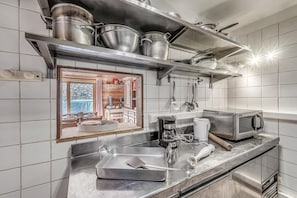 A modern kitchen with stainless steel appliances, a coffee maker, a microwave, and a sink.