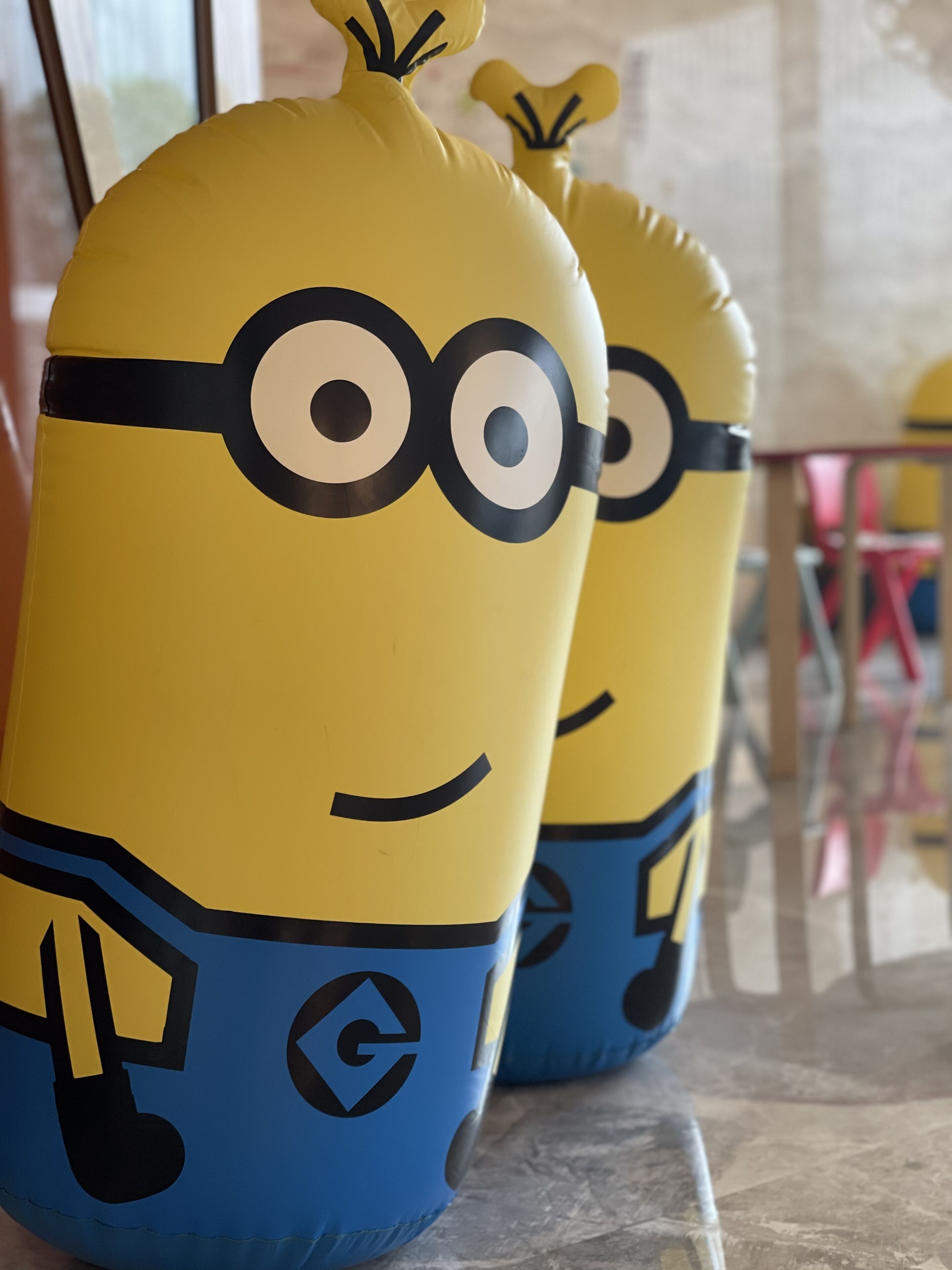 Two yellow and blue inflatable toys with Minion faces.