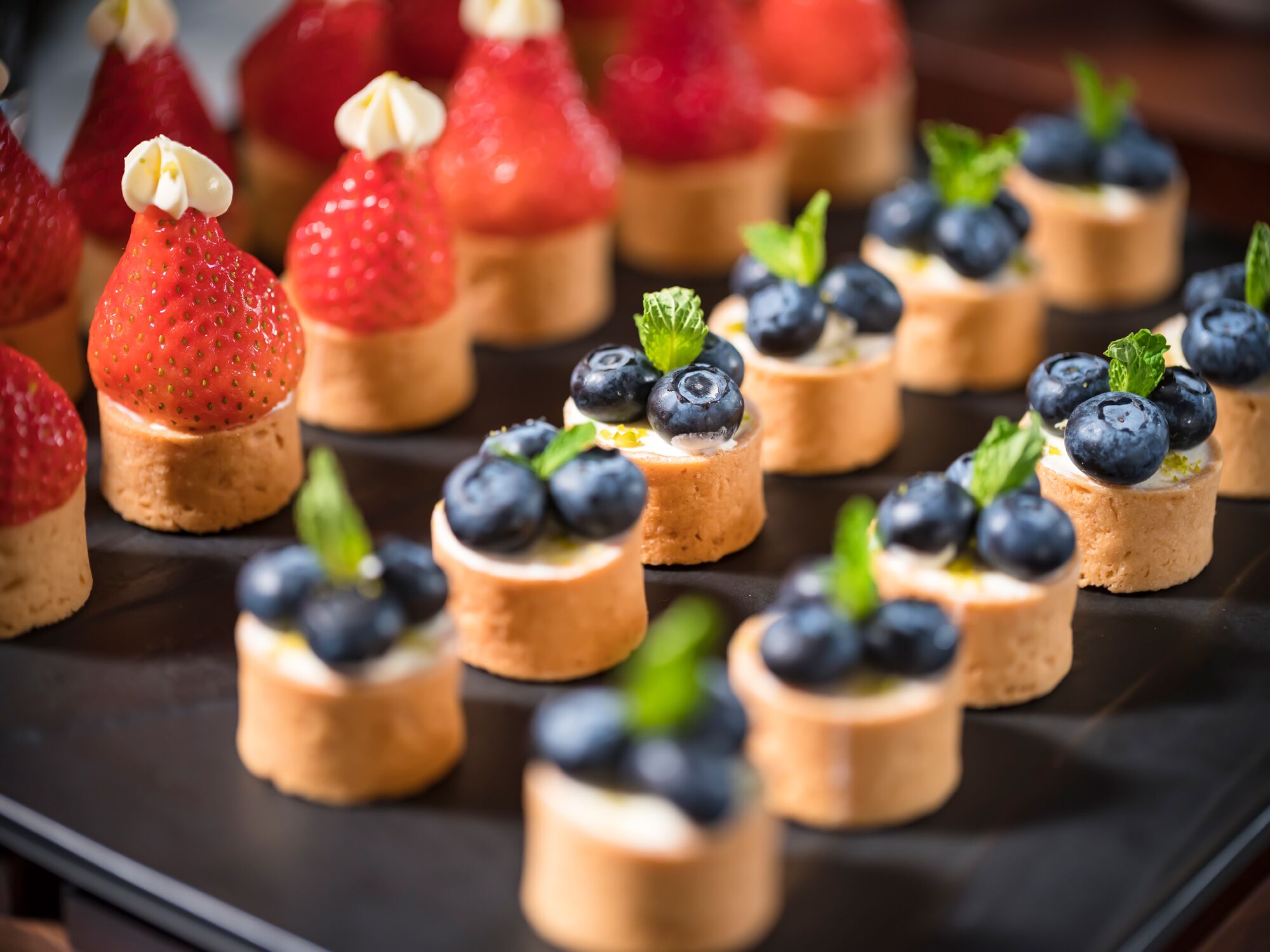A dessert platter with various fruit-topped pastries.