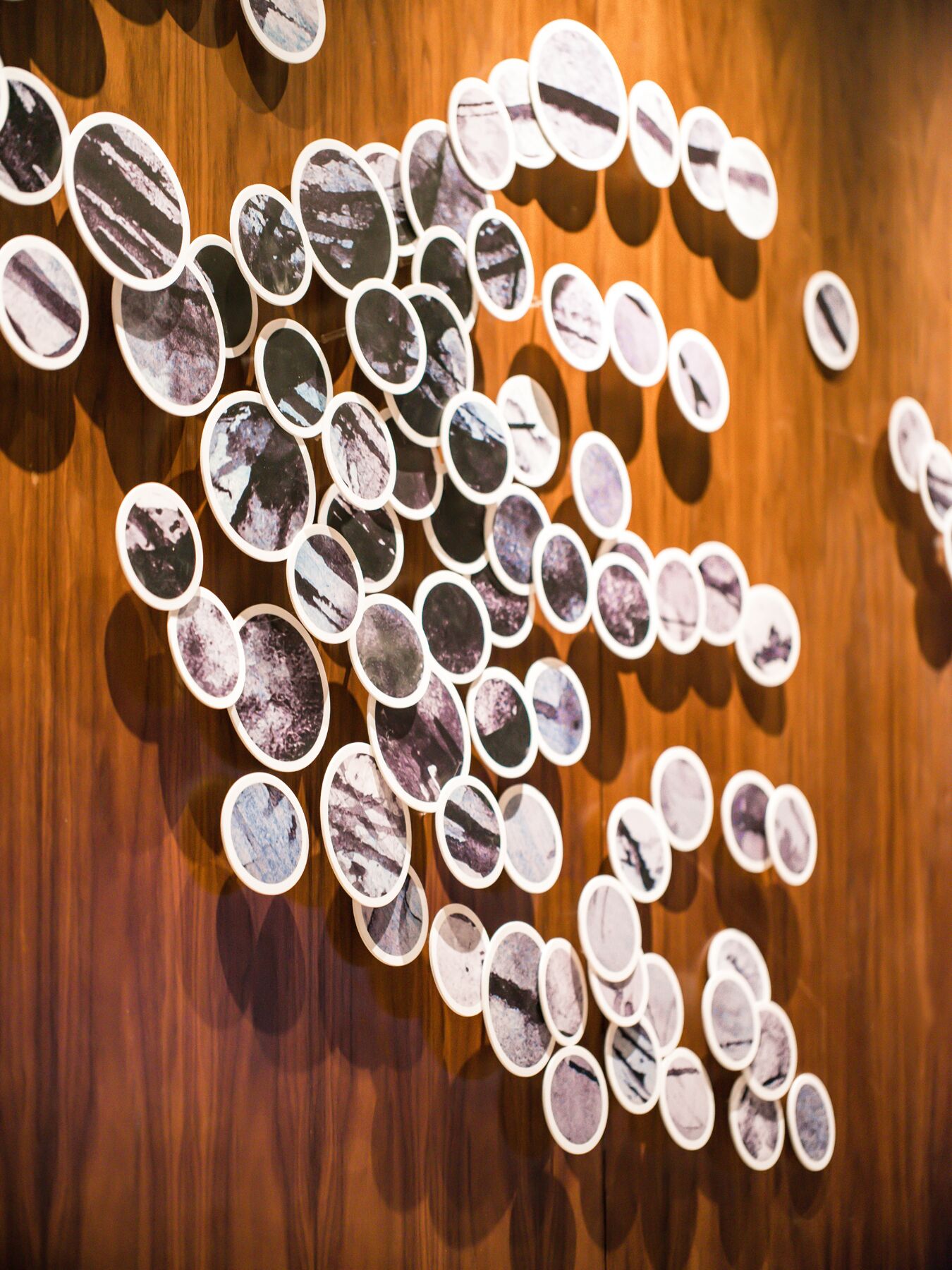 A collection of oval-shaped photographs arranged on a wooden surface.