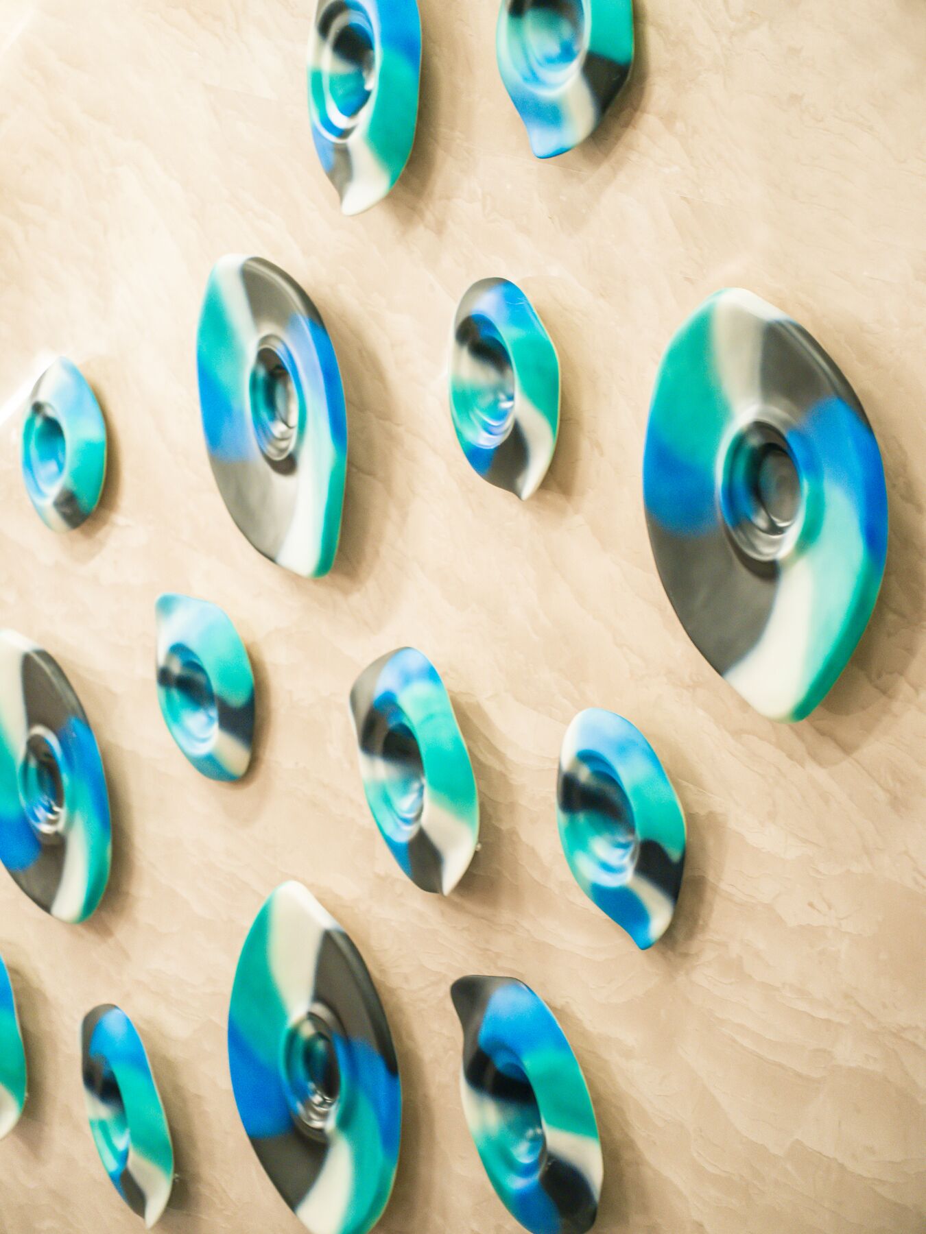 A close-up of multiple metallic objects with a reflective surface, arranged on a textured surface.