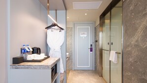 Un baño moderno con toallero, zona de ducha y puerta con panel de control.