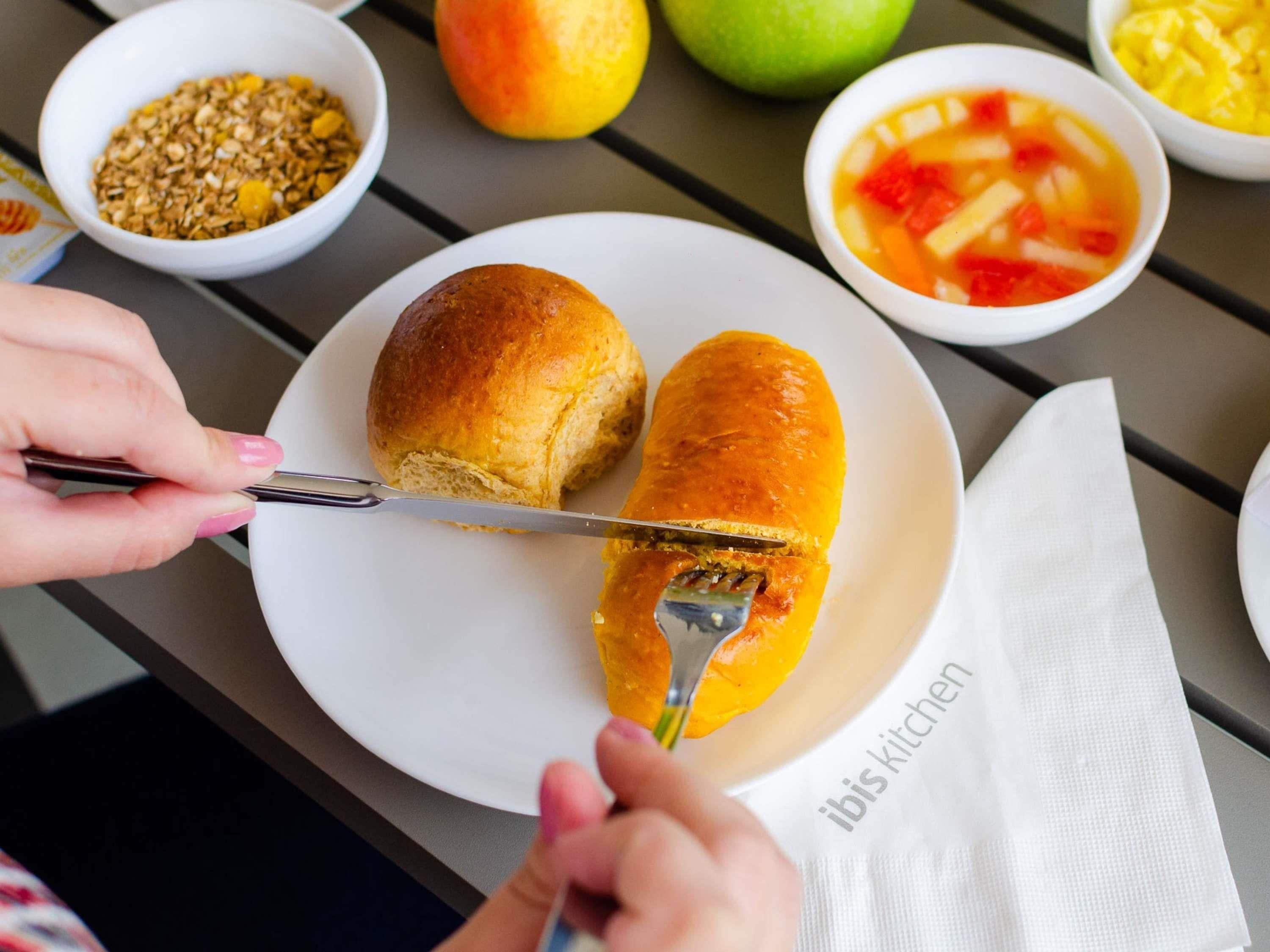 Ein Teller mit zwei Brötchen, einer Suppenschüssel und einer Schüssel Müsli.