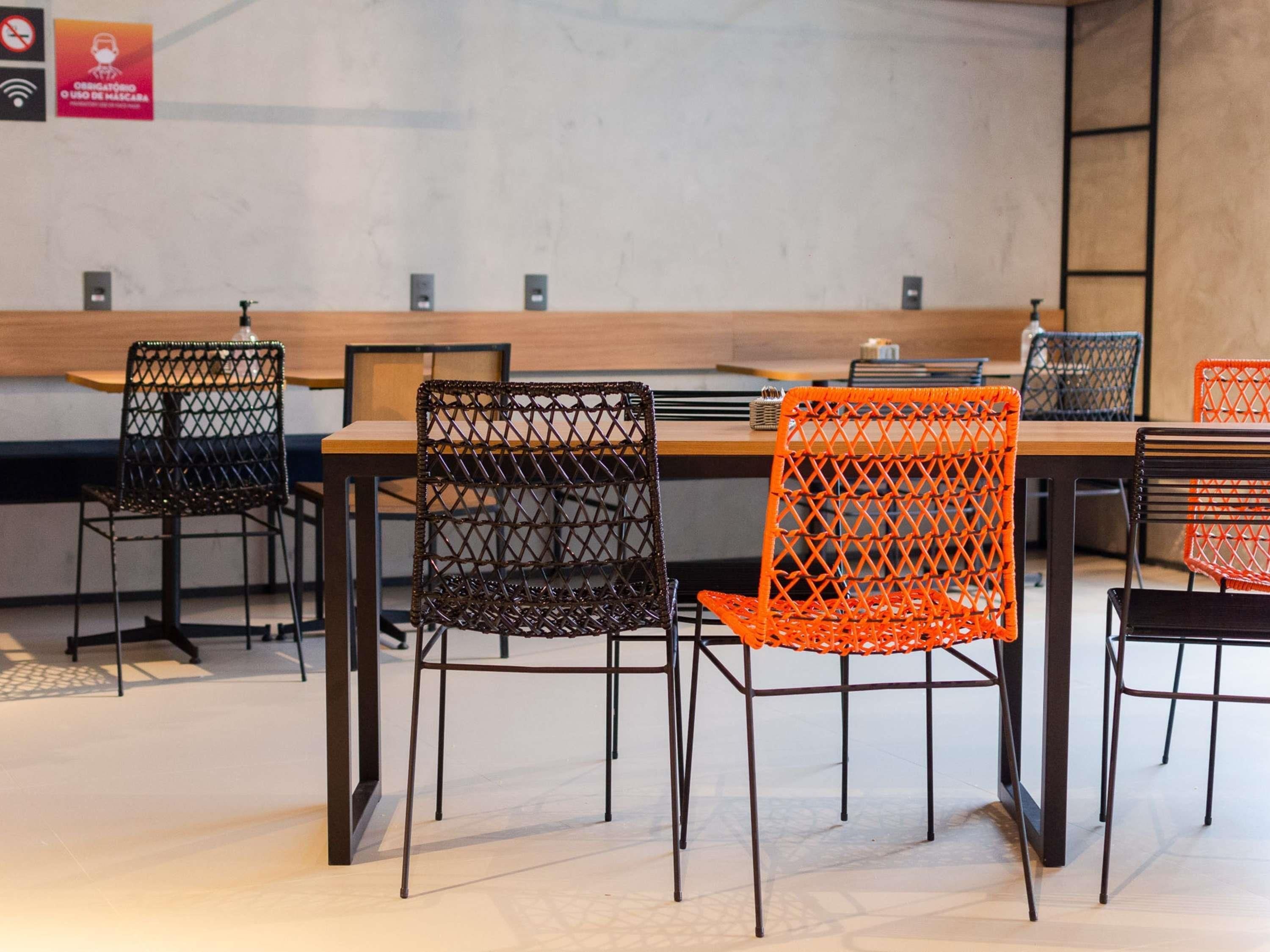 A dining area with a long table and chairs with a lattice design.