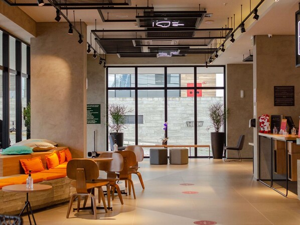 Un interior moderno con una zona de estar, una recepción y grandes ventanales.