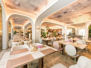 A spacious restaurant with high ceilings, arched walkways, and modern lighting fixtures. Tables are arranged in a linear fashion with chairs. - Mercure Xian City Centre (Xi'an)