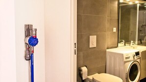 A bathroom with a toilet, washing machine, and a shower area. - APARTEMENT CANNES CROISETTE 4th floor (CANNES)