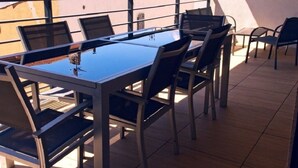 A sunlit outdoor dining area with a glass-top table and metal chairs. - APARTEMENT CANNES CROISETTE 4th floor (CANNES)