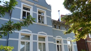 A multi-story building with a light blue facade, white trim, and multiple windows. - Morizan (Röbel/Müritz)
