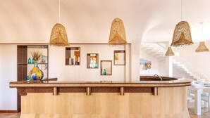 A reception area with a curved counter, multiple hanging wicker lamps, and a staircase in the background. - Villa Stella Blu by BarbarHouse (San Pietro in Bevagna)