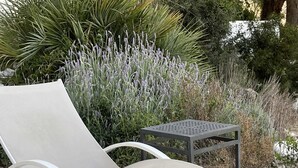 Een lounge stoel met metalen frame en een witte kussen, geplaatst op een houten terras.