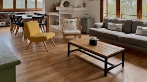 Een ruime woonkamer met een eettafel, stoelen, een bank en een salontafel.